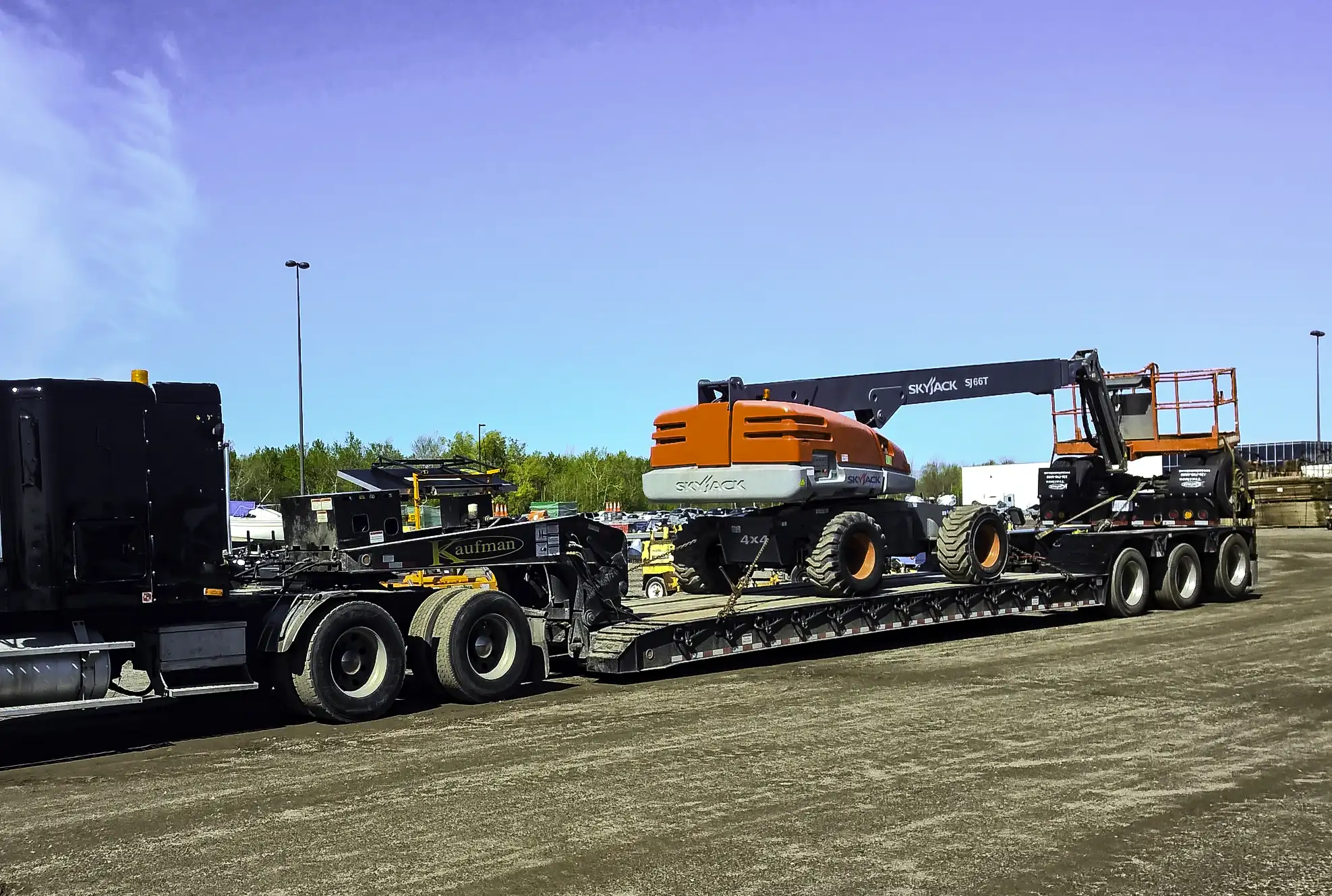 Skyjack boom lift loaded and a low boy trailer.